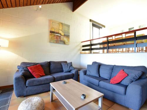 un soggiorno con 2 divani blu e un tavolino da caffè di Cozy Villa in Vielsalm with Private Garden a Vielsalm