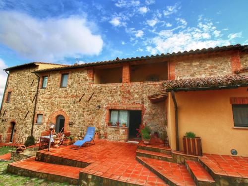 a brick house with a patio in front of it at Belvilla by OYO Casa Ginepro in San Quirico dʼOrcia