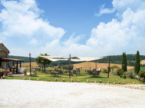 an outdoor patio with tables and chairs in a field at Apartment near Pisa, Beaches in Guasticce