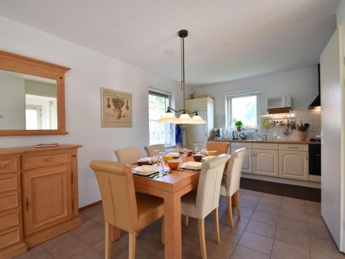 een keuken en eetkamer met een houten tafel en stoelen bij Holiday home in the village of Zonnemarie nearby kids beach in Zonnemaire
