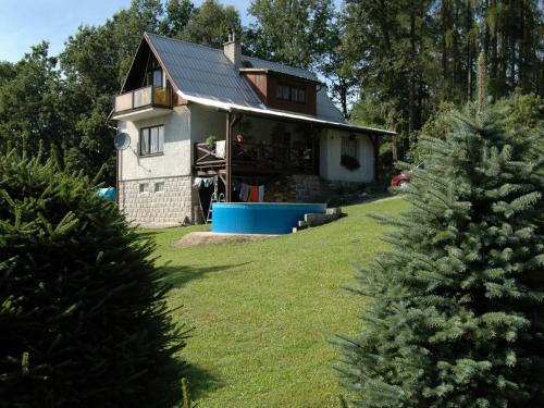 a house with a christmas tree in front of it at House with the pool and fenced garden in Hnanice