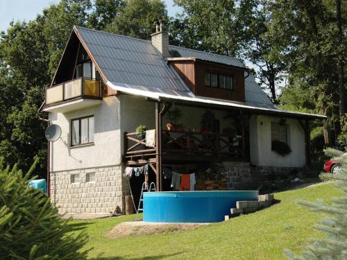 a house with a metal roof on top of it at House with the pool and fenced garden in Hnanice