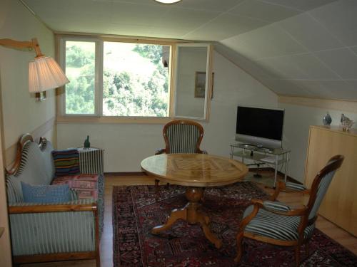 sala de estar con mesa, sillas y TV en Chalet in M rel with Terrace Parking Furniture en Mörel