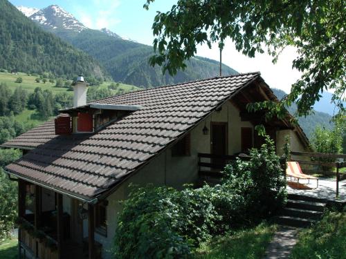 una casa con techo con montañas al fondo en Chalet in M rel with Terrace Parking Furniture en Mörel