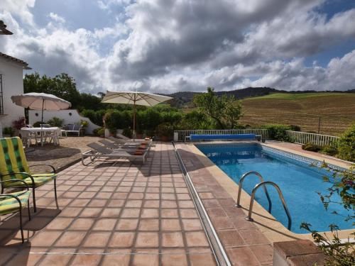 AlmogíaにあるLovely Holiday Home with Private Swimming Pool in Almog aのパティオ(椅子、パラソル付)