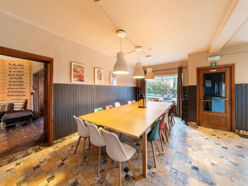 uma sala de jantar com uma mesa longa e cadeiras em Beautiful group house with large garden em Gouvy