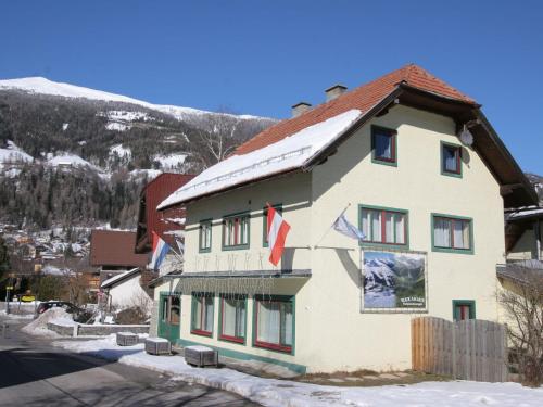 a building with flags on it in the snow at Apartment in St Michael im Lungau near Katschberg in Sankt Michael im Lungau