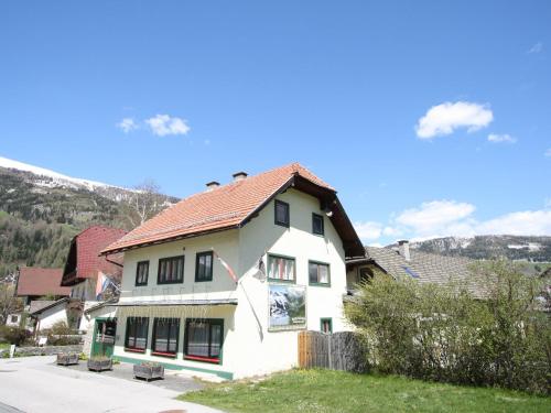 Biały dom z czerwonym dachem na ulicy w obiekcie Apartment in St Michael near Ski Slopes w mieście Sankt Michael im Lungau