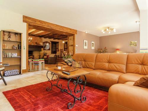 a living room with a couch and a table at Large farmhouse with private garden in Nantheuil