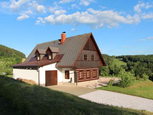 dom z dachem gambrel na wzgórzu w obiekcie Cottage near Ski area in Stupna Czech Republic w mieście Vidochov