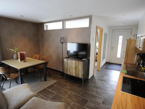 een woonkamer met een tafel en een televisie bij Apartment in Untertauern near ski area in Untertauern
