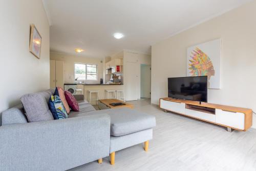a living room with a couch and a flat screen tv at Lotus Stay Manly - Apartment 29F in Sydney