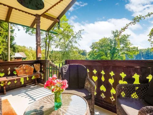 eine Terrasse mit Stühlen und einem Tisch mit Blumen darauf in der Unterkunft Quaint holiday home with fireplace and terrace in Pähl