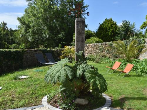 a garden with two chairs and a plant at Holiday Home near Pointe du Raz & Sea in Kersaudy