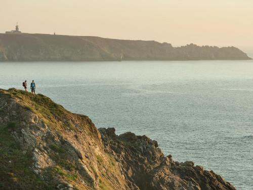 two people standing on a cliff near the water at Holiday Home near Pointe du Raz & Sea in Kersaudy