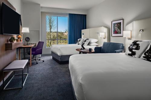 a hotel room with two beds and a desk at Crowne Plaza North Augusta, by IHG in North Augusta