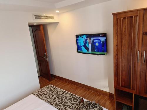 1 dormitorio con TV de pantalla plana en la pared en Ocean View Quy Nhon Hotel en Quy Nhon