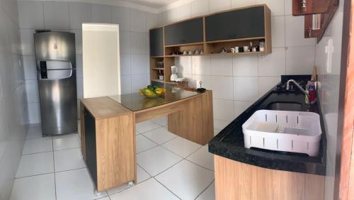 eine Küche mit einer Theke mit einer Spüle und einem Kühlschrank in der Unterkunft Rio Claro Comfort Hostel e Suítes in São Luís