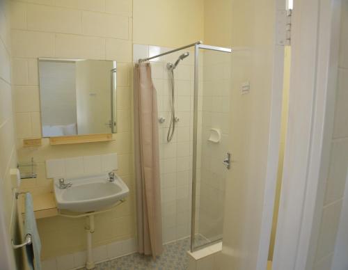 a bathroom with a sink and a shower with a mirror at Glossop Motel in Winkie