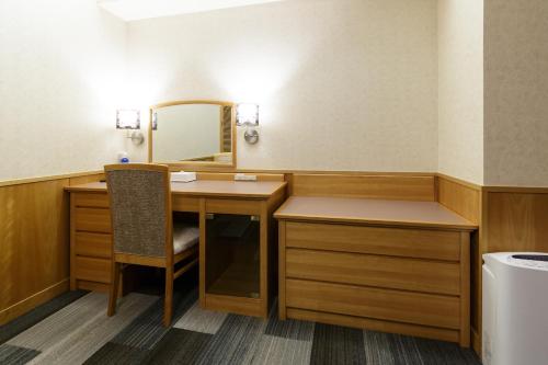 a bathroom with a desk and a mirror at Kochi Pacific Hotel in Kochi