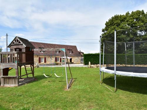 um quintal com um parque infantil com um trampolim em Cozy Holiday Home in Saint L on sur em Sergeac