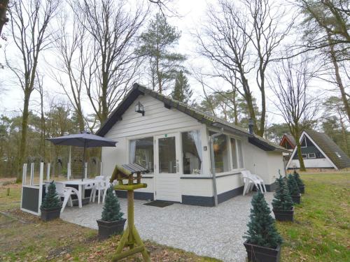 StramproyにあるSerene Holiday Home in Limburg amid a Forestの小さな白いコテージ(テーブル、傘付)