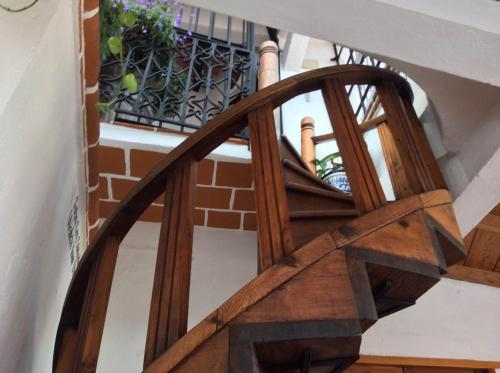 a wooden spiral staircase in a building with a balcony at Hotel Mi Casita in Taxco de Alarcón