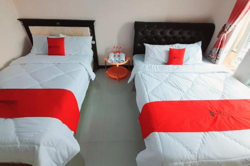 two beds sitting next to each other in a room at RedDoorz Syariah near Komplek Candi Arjuna Dieng 2 in Dieng