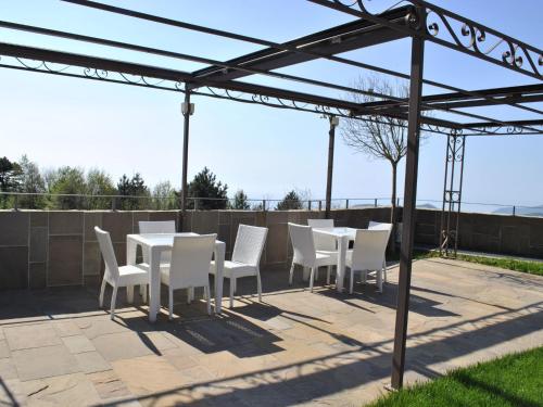 MaglioloにあるBelvilla by OYO Vista Gentileのパティオ(白い椅子、テーブル付)