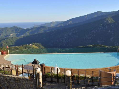 une grande piscine avec des montagnes en arrière-plan dans l'établissement Belvilla by OYO Vista Gentile, à Magliolo