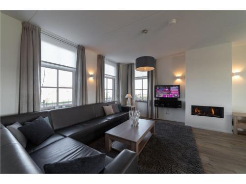 uma sala de estar com um sofá e uma mesa em Vacation home with sauna in Zeeland em Colijnsplaat