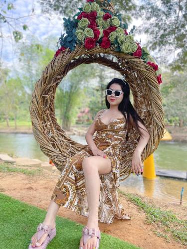 a woman is sitting on a wreath of flowers at JK Riverview Resort in Ban Song Phi Nong