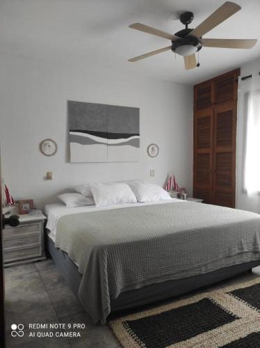 a bedroom with a bed and a ceiling fan at DEPAR DE PLAYA Casa Blanca Same in Same