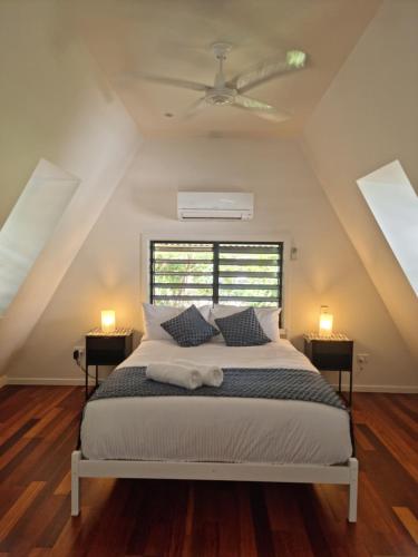 a bedroom with a bed with a ceiling fan at Canopy 5 Chalet in Nelly Bay