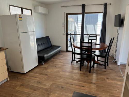 una cucina e una sala da pranzo con tavolo e frigorifero di Lakes Main Holiday Park a Lakes Entrance