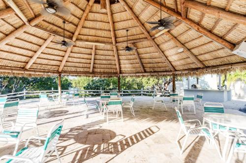 a patio with tables and chairs under a wooden roof at Kawama Yacht Club A4 in Key Largo