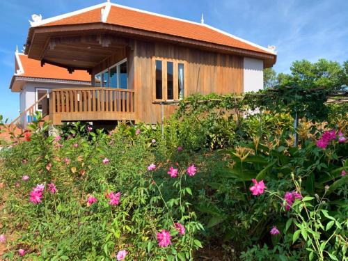 a house with a deck and flowers at Sumeru in Sen Monorom