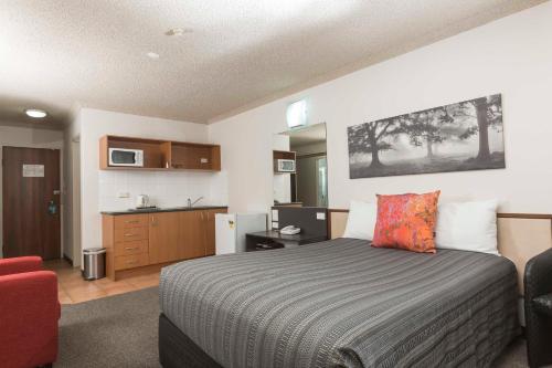a hotel room with a bed and a kitchen at Belconnen Way Hotel & Serviced Apartments in Canberra