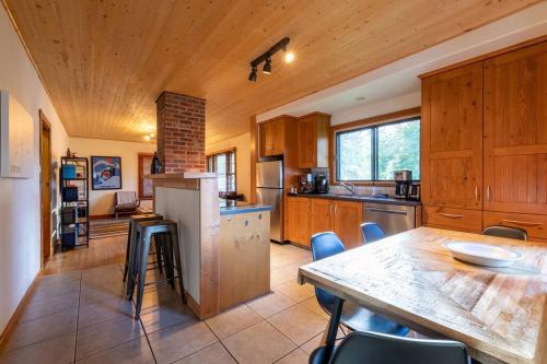a kitchen with a wooden ceiling and a table and chairs at Knotty Pine Lodge in Golden