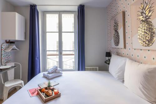 une chambre avec un lit blanc avec une fenêtre dans l'établissement WS Opéra - Galeries Lafayette, à Paris