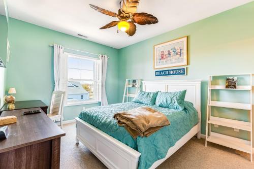 a bedroom with blue walls and a bed and a desk at Villas at Bay Crossing - 34670 Villa Circle Unit #2304 in Lewes