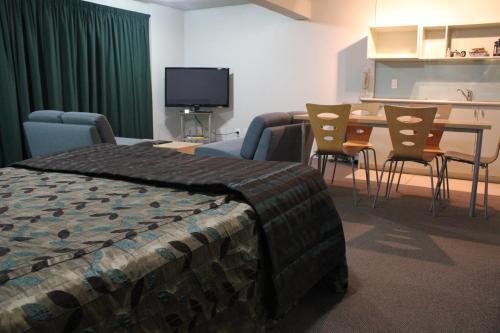 a bedroom with a bed and a table and chairs at Edgewater Motor Lodge in Napier