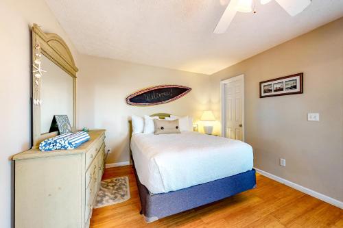 a bedroom with a white bed and a wooden floor at Smiles N Waves in Panama City Beach