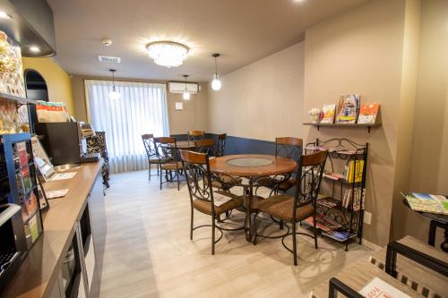 Framboise KYOTO Hotel de charme في كيوتو: غرفة طعام مع طاولة وكراسي