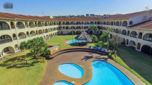 an aerial view of a building with a swimming pool at Cabanas del Mar in Amanzimtoti