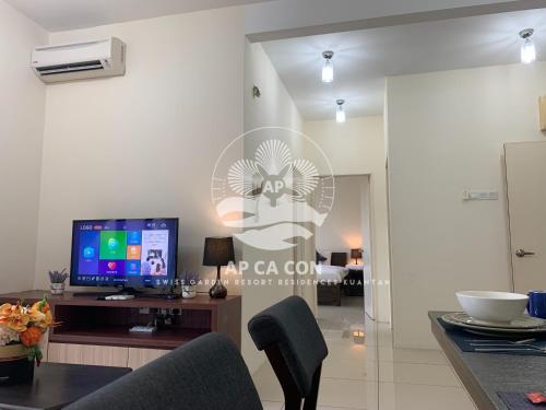 a living room with a television and a table at SG Resort Residences Kuantan by AP CA CON in Kampung Sungai Karang