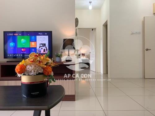 a vase of flowers on a table in a room at SG Resort Residences Kuantan by AP CA CON in Kampung Sungai Karang