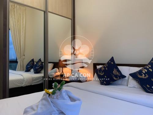 a bedroom with two beds and a mirror at SG Resort Residences Kuantan by AP CA CON in Kampung Sungai Karang