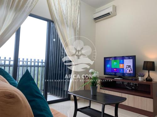 a living room with a tv and a table at SG Resort Residences Kuantan by AP CA CON in Kampung Sungai Karang