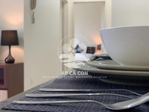 a table with a plate and a cup on it at SG Resort Residences Kuantan by AP CA CON in Kampung Sungai Karang